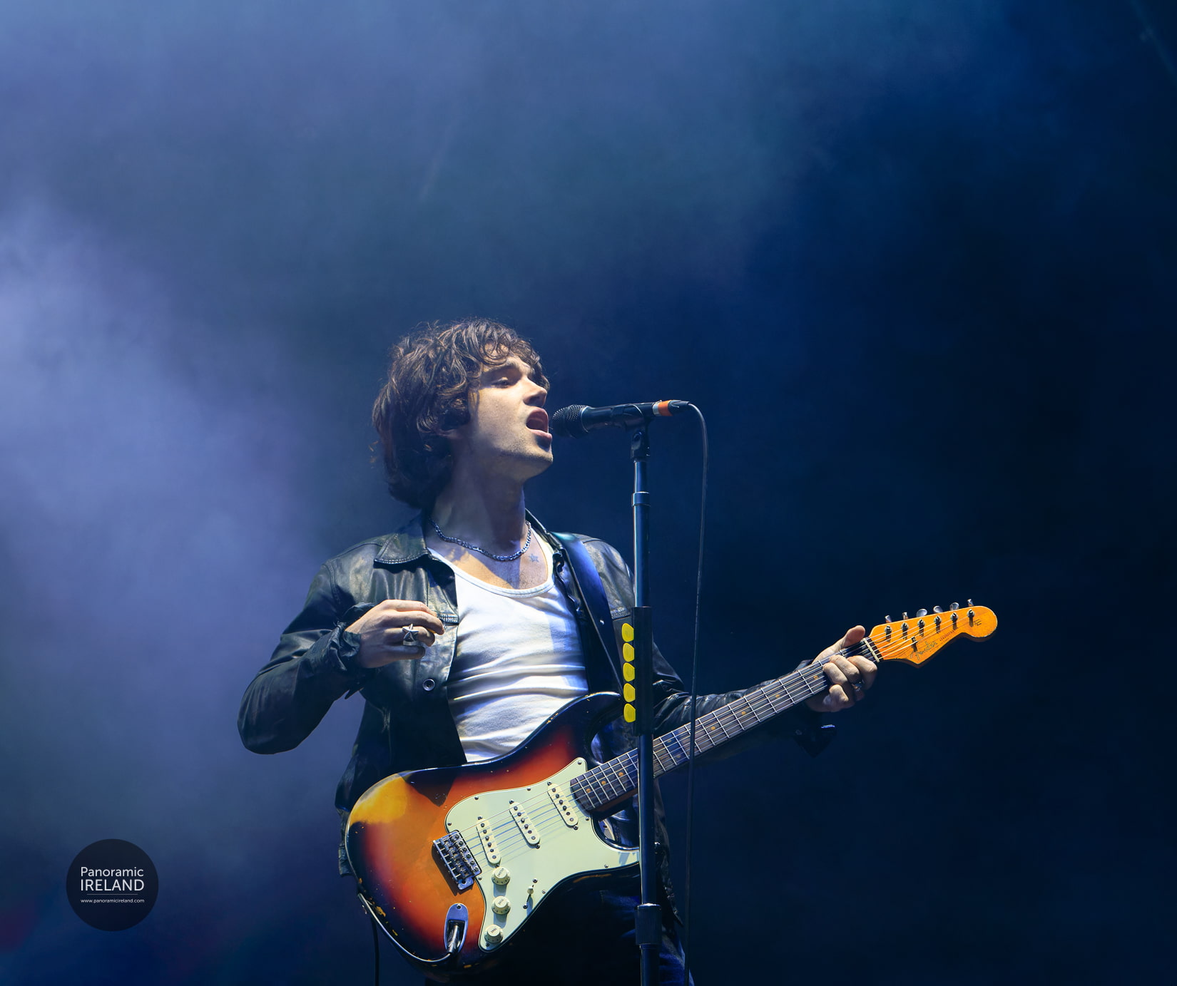 Elijah Hewson, singer and guitarist from Irish rock band Inhaler performing at Electric Picnic with moody stage lighting.