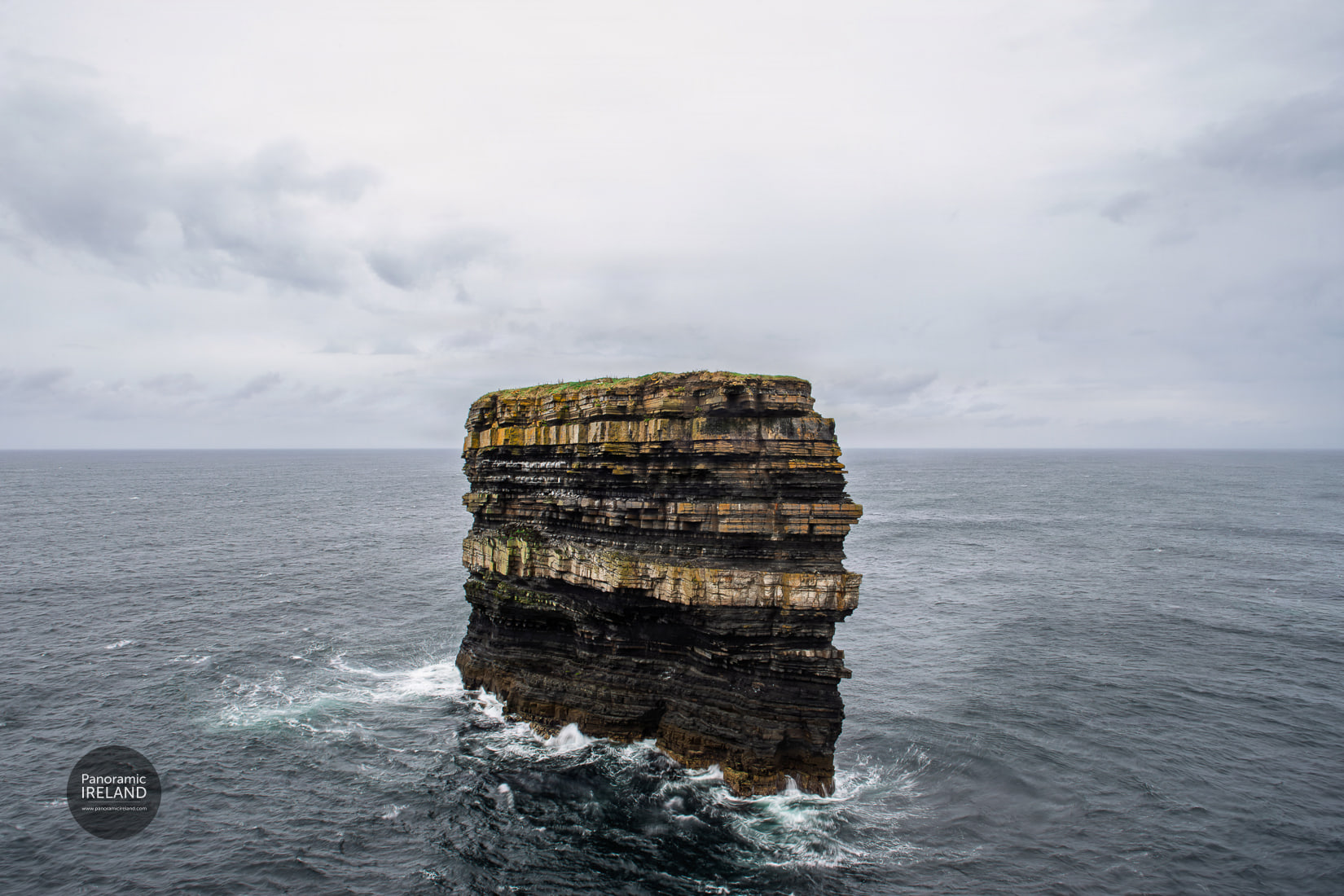 Dun Briste sea stack on the Mayo coast under stormy skies, Atlantic swell softened by a long exposure.