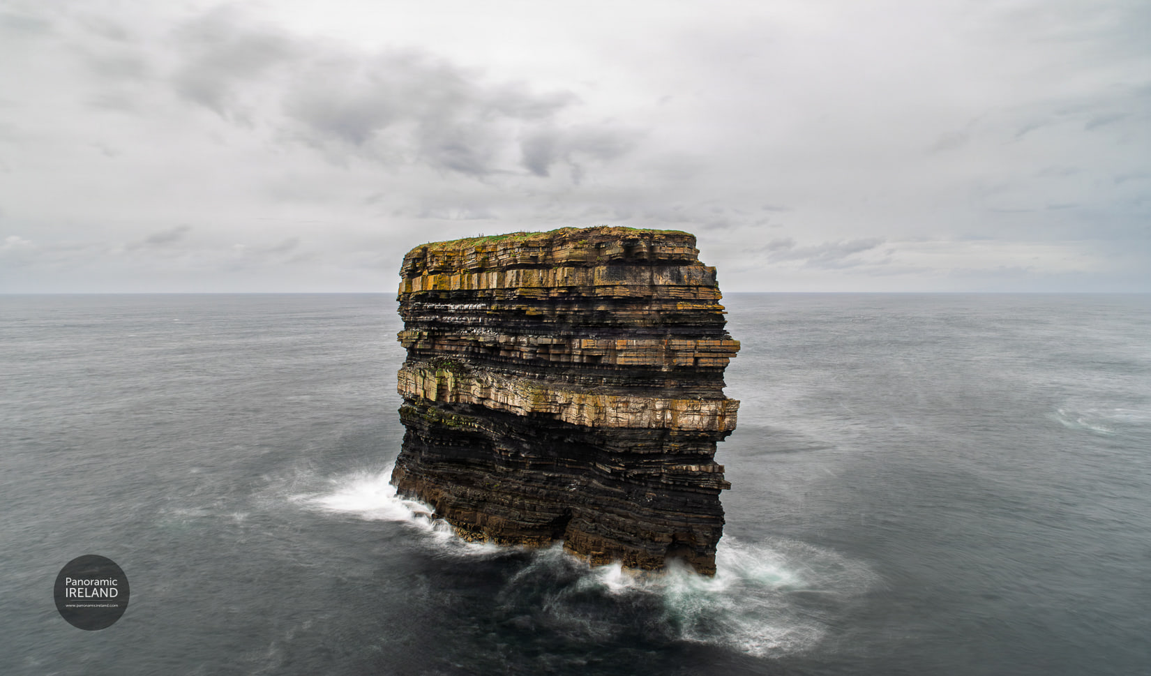 Dun Briste — a five-second exposure. Dun Briste sea stack on the Mayo coast, a five-second exposure softening the Atlantic around its base under a heavy sky.